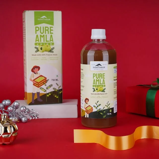 The Pure Amla Juice carton and bottle on a red background with wrapped gifts and a gold ribbon.